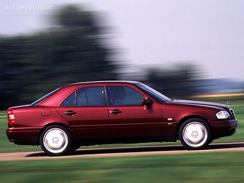 Front three-quarter view of a 1998 Mercedes-Benz C280 sedan in silver, parked on a paved surface, showcasing its classic design