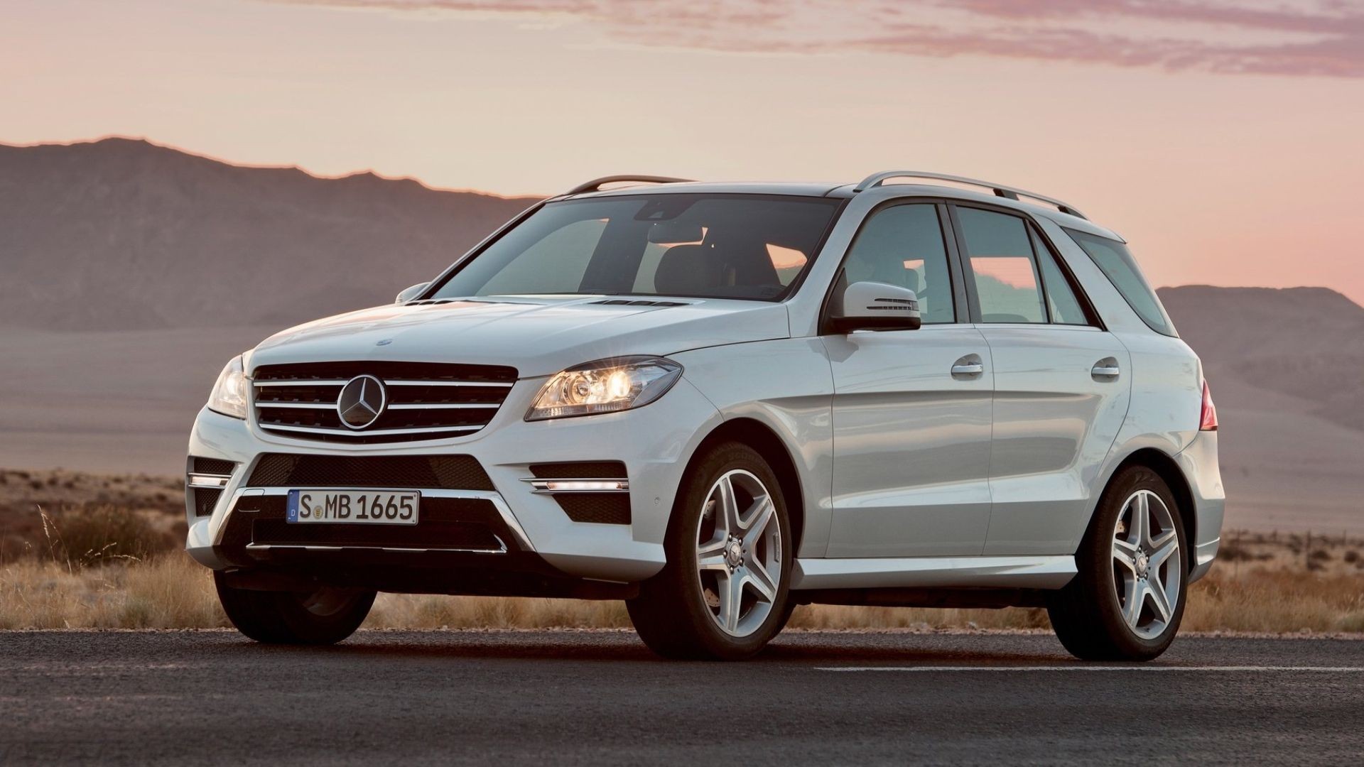 White 2014 Mercedes-Benz M-Class parked, highlighting its larger, more traditional SUV proportions.