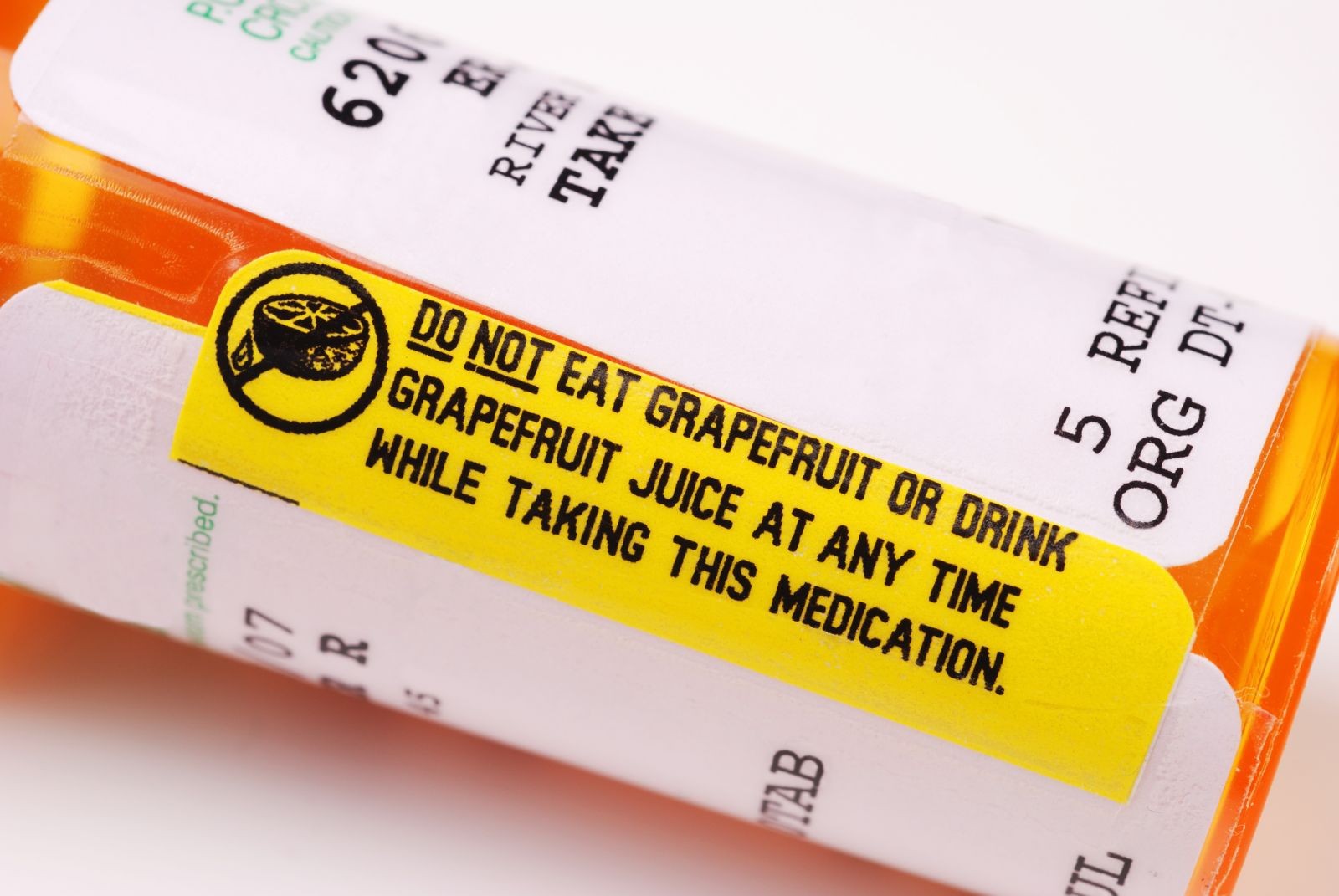 Grapefruit and pills, representing the dangerous interaction between grapefruit juice and certain medications like benzodiazepines.