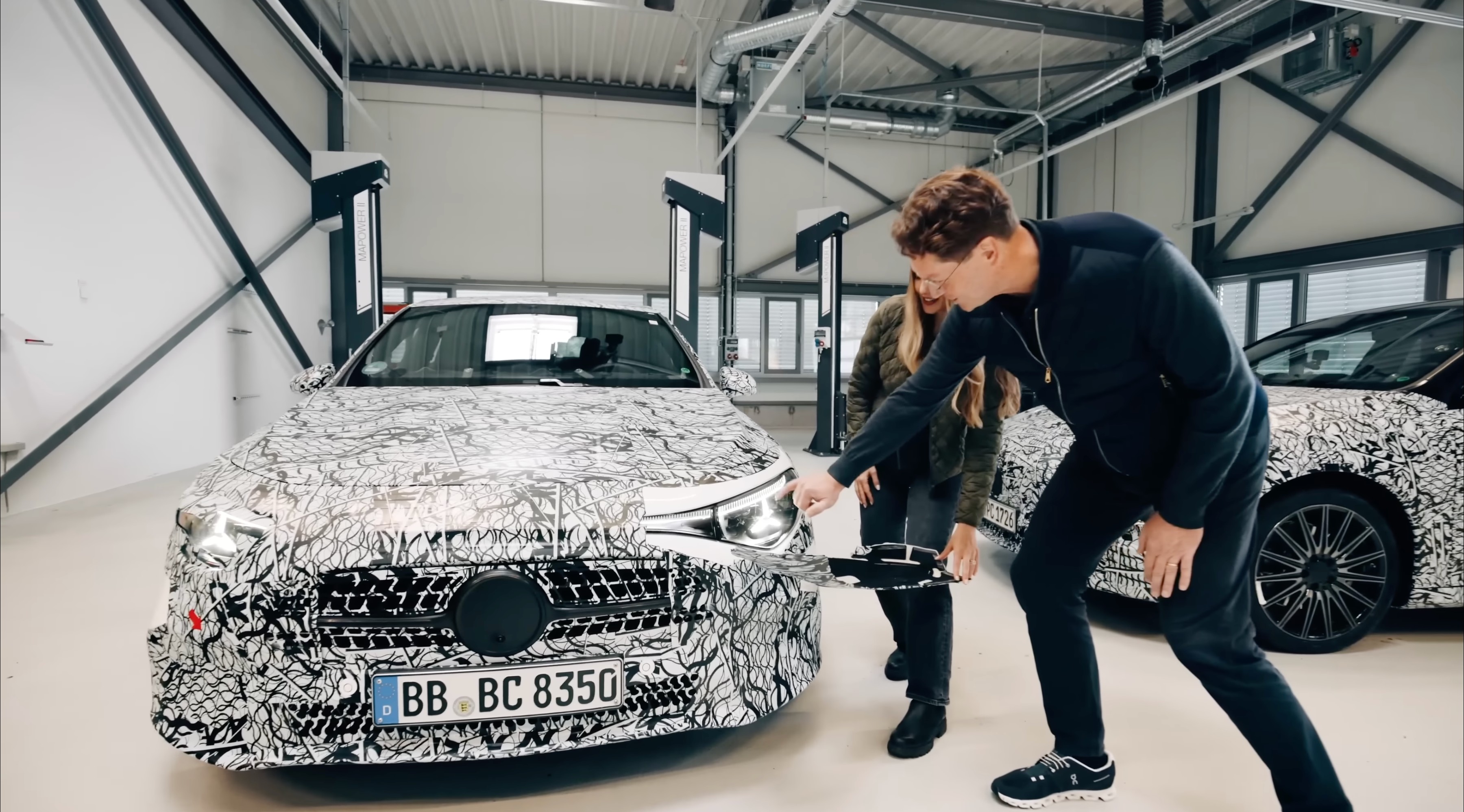 Camouflaged Mercedes-Benz CLA front view showcasing headlight design