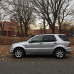 1999 Mercedes Benz ML430 front view parked on street, showcasing its boxy SUV design from the late 90s.