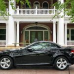 Front view of a black 2006 Mercedes-Benz SLK 280 parked on a paved area, showcasing its sleek design and iconic Mercedes grille.