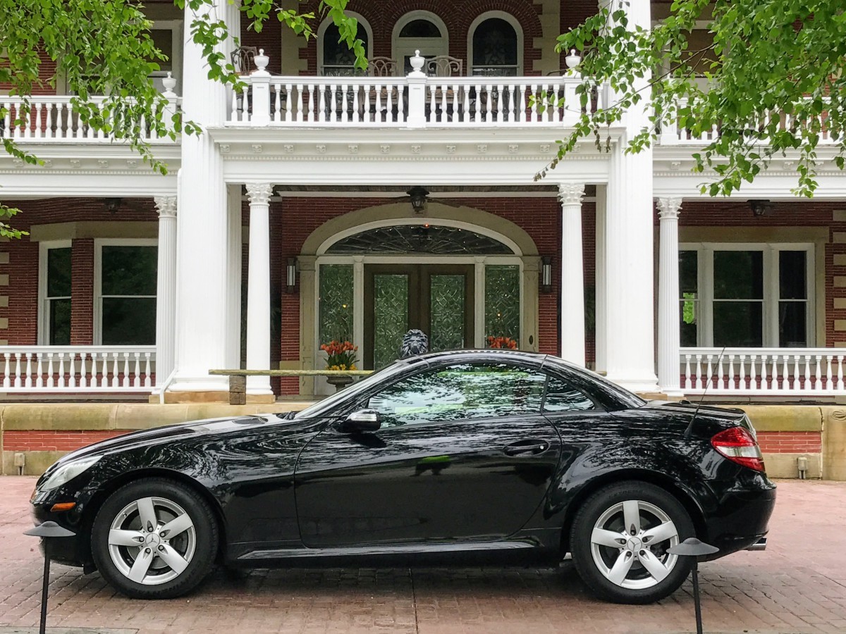 Front view of a black 2006 Mercedes-Benz SLK 280 parked on a paved area, showcasing its sleek design and iconic Mercedes grille.