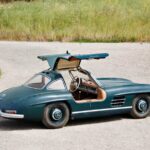 Classic 1950s Mercedes-Benz 300SL Gullwing and Roadster models showcased before auction, highlighting vintage car appeal for collectors