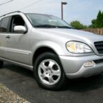 Front view of a silver 2002 Mercedes-Benz ML320, showcasing its refreshed headlights and bumper design.