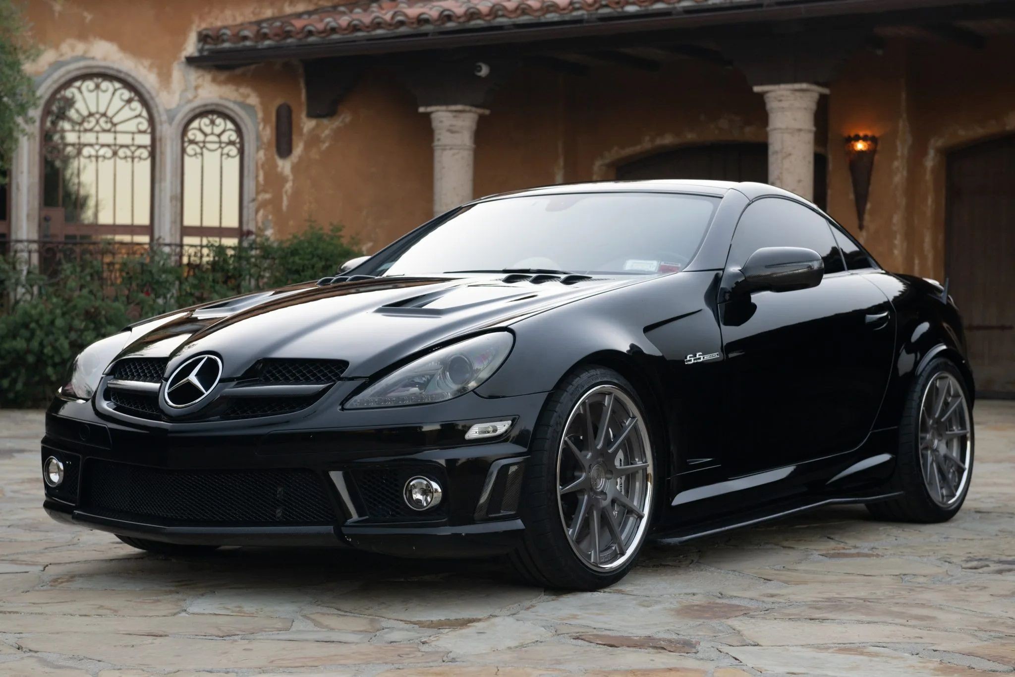 A silver Mercedes-Benz SLK Class car parked outdoors, showcasing its sleek design and convertible top